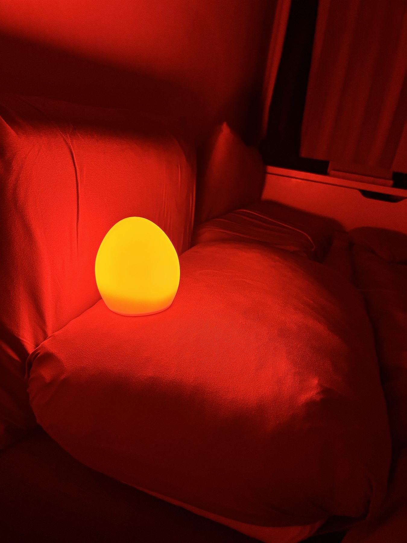 Owlnest Lume real nighttime amber glow on a sofa